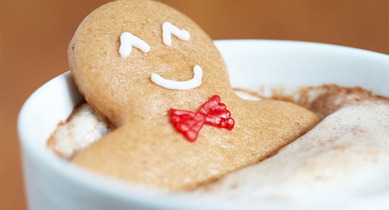 muñequito de galleta dentro de una taza de café espumoso 